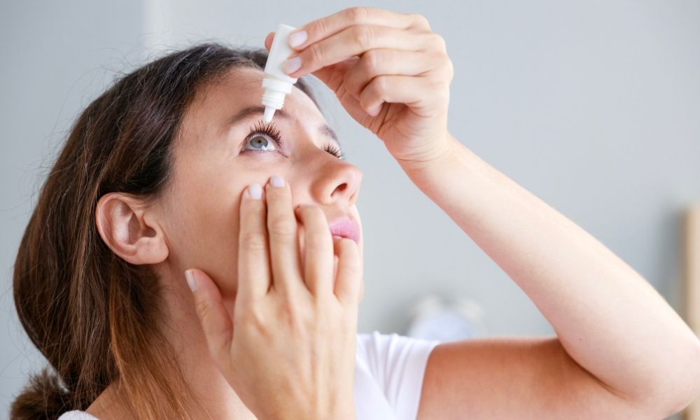 אישה עם עיניים יבשות מטפטפת נוזל לעין